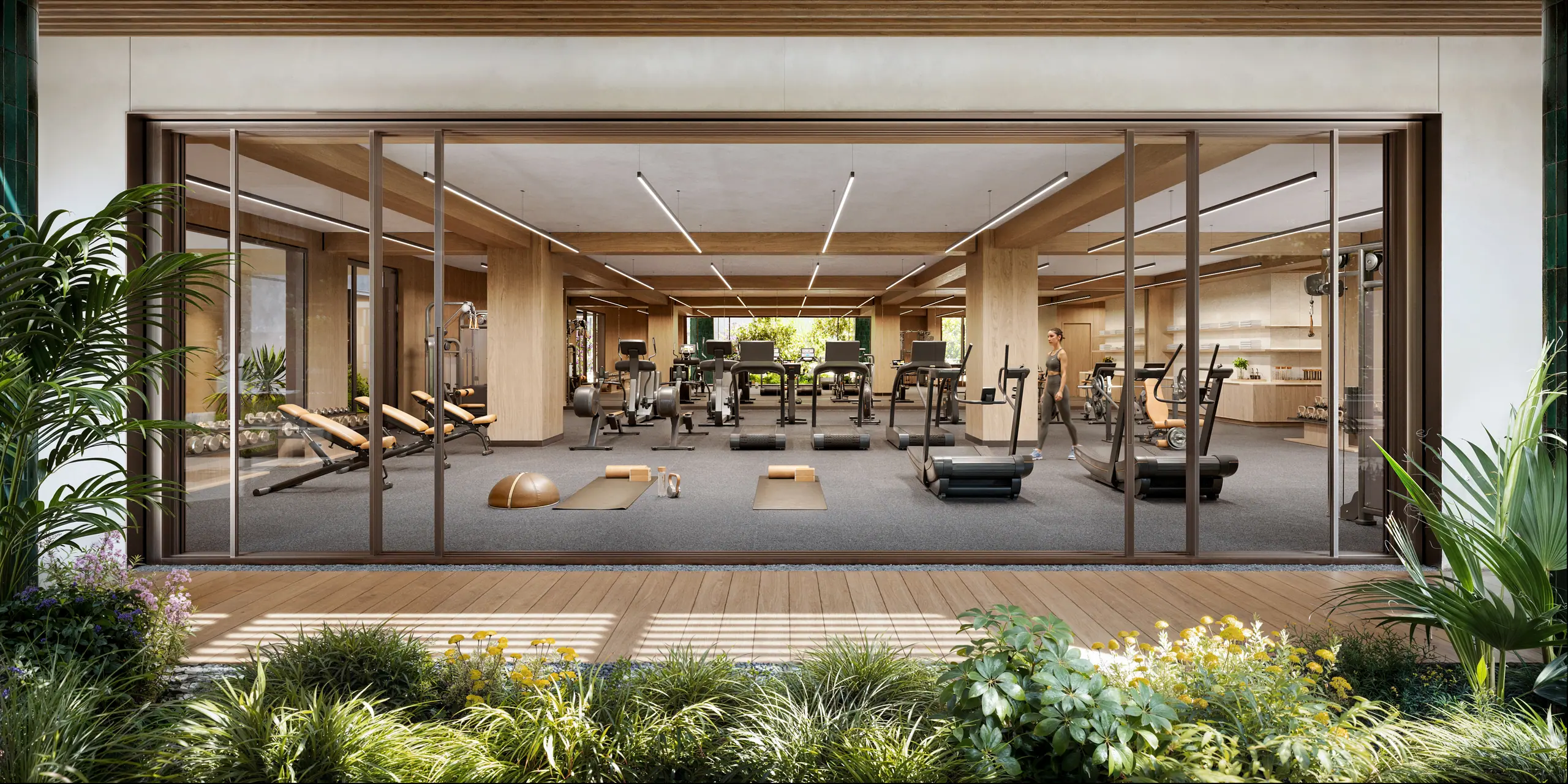 Rendering of the fitness center seen through full-height glass walls, with cardio equipment, weights and a stretching area opening onto a planted terrace
